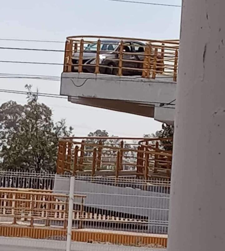 Sujeto intenta cruzar puente peatonal en coche; se queda atorado